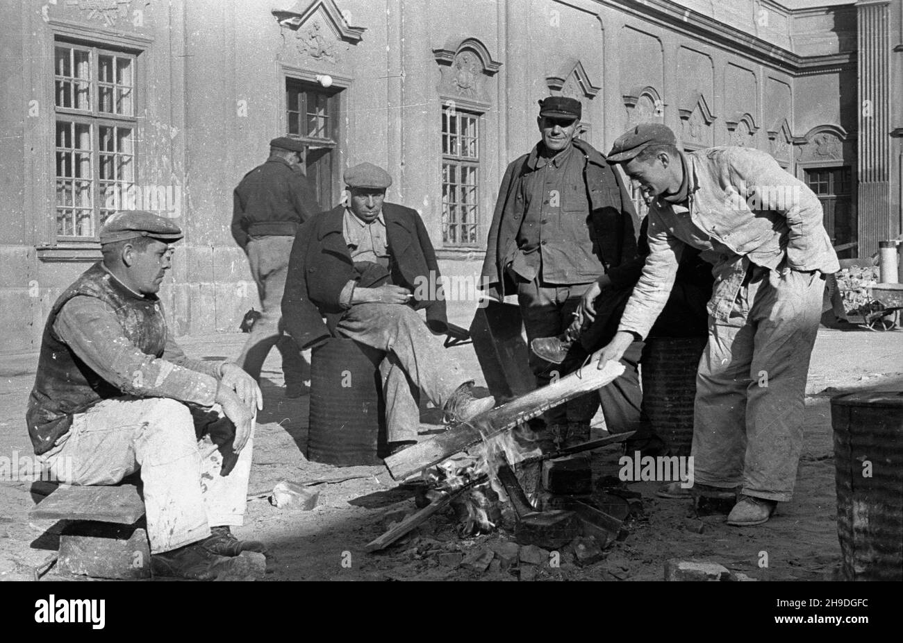 Warszawa, 1947-10. Odbudowa pa³acu Pod Blach¹. NZ. Robotnicy podczas przerwy w pracy ogrzewaj¹ siê przy ognisku na dziedziñcu pa³acu. ps/gr PAP Dok³adny dzieñ wydarzenia nieustalony. Warschau, 1947. Okt. Wiederaufbau des Pod Blacha Palastes. Im Bild: Arbeiter während einer Arbeitspause, die sich durch ein Feuer auf dem Hof des Palastes erwärmen. ps/gr PAP Stockfoto