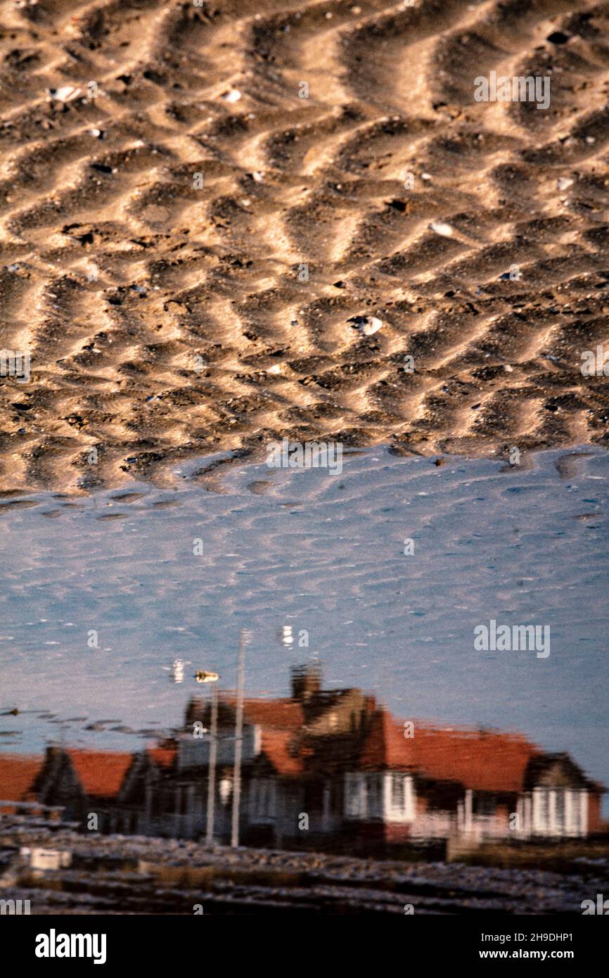 Intime Landschaft der Reflexion entlang des Sandstrandes mit plätscherndem Sand Stockfoto