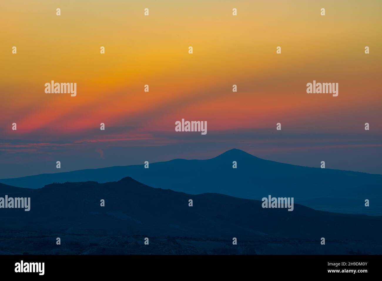 Mountain Peak. Berggipfel und Silhouetten bei Sonnenuntergang mit dramatischen Wolken. Hintergrundfoto bei Sonnenuntergang, Dämmerung oder Dämmerung Stockfoto