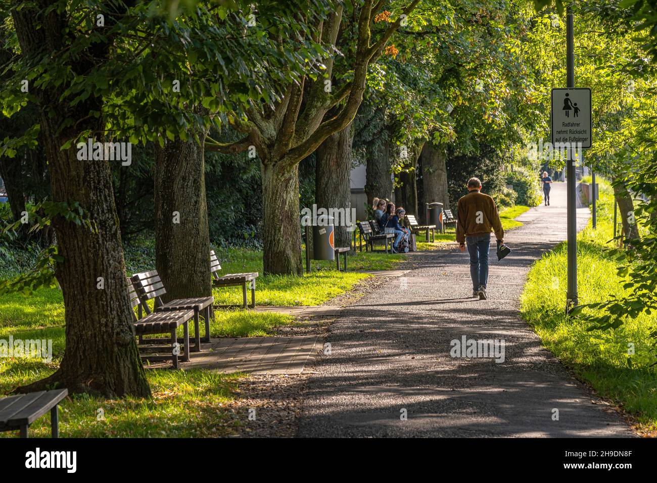 Outdoor-Leben auf den Fußgängerwegen entlang der Donau in Ulm. Familien und Senioren bummeln in der Sommersonne. Ulm, Tübingen, Deutschland Stockfoto