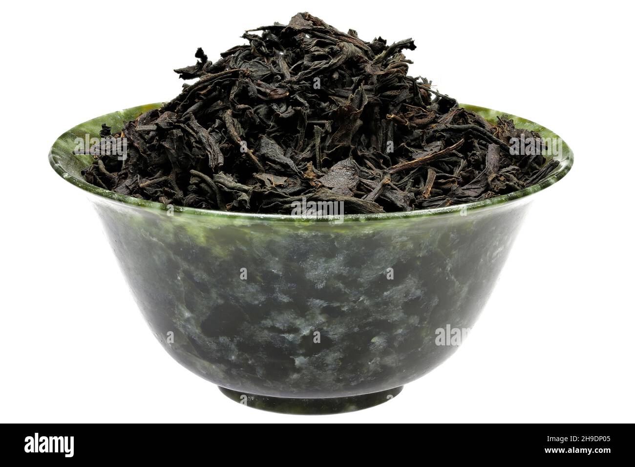 Ceylon Schwarzer Tee in einer vintage Spinat Jade Schüssel isoliert auf weißem Hintergrund Stockfoto