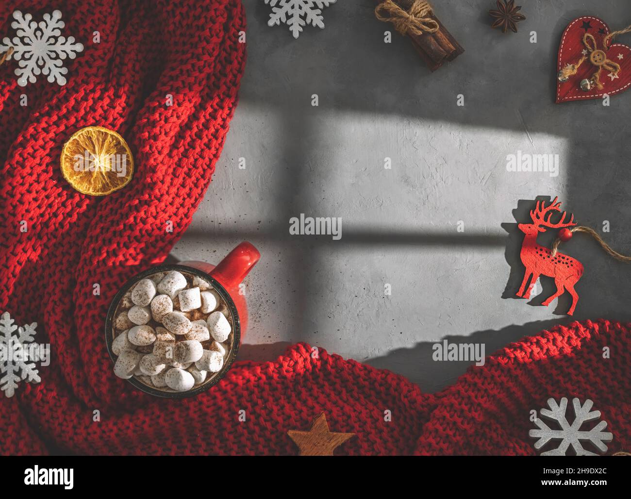 Becher mit Süssmarmelibe, rote Decke auf grauem Hintergrund, Licht vom Fenster, Schatten. Winter, Neujahr, weihnachten. Draufsicht Stockfoto