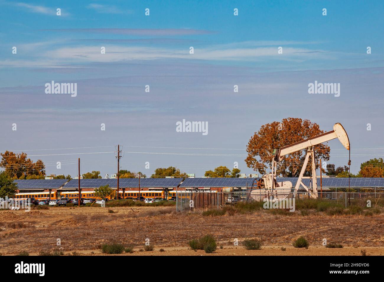 Pumpjack in der Nähe von Schulbussen, Arvin, Kern County, Kalifornien, USA Stockfoto