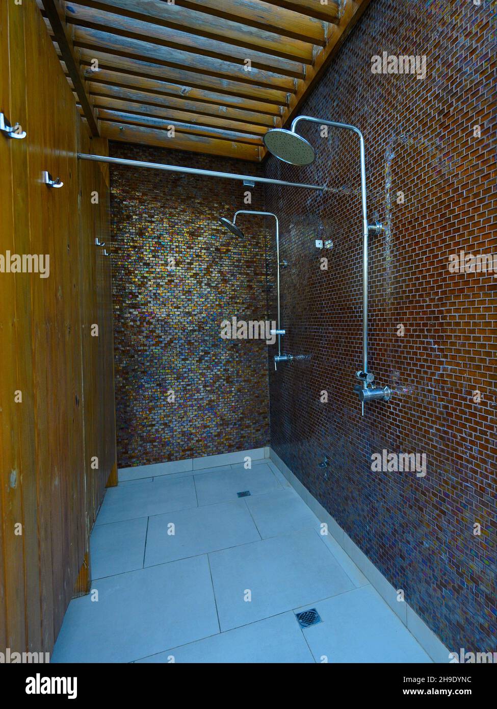 Duschraum mit Tageslicht auf der rechten Seite. Bad mit Kartoffelwasser Holzwand und Naturstein. Umwelt Badezimmer für Touristen. Stockfoto