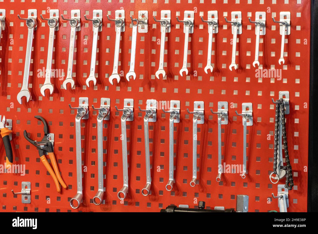Werkzeugkits, die in der Werkstatt an der Wand hängen Stockfoto