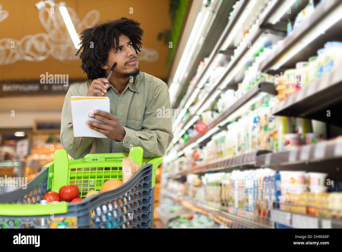 Black Man Holding Einkaufsliste Berechnung Der Lebensmittelpreise Im Supermarkt Stockfoto