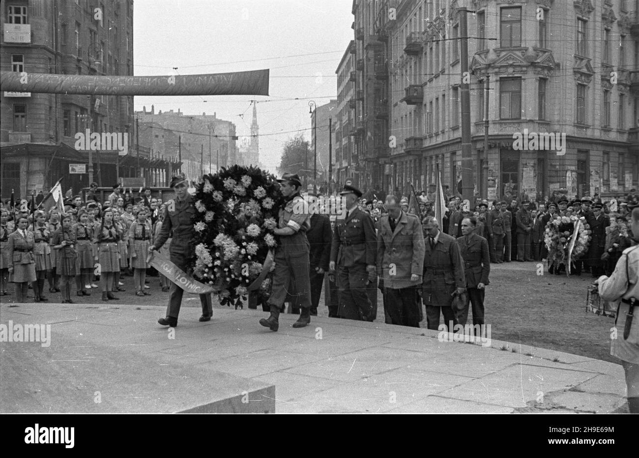 Warszawa, 1947-10-12. Inauguracja Tygodnia Ligi Lotniczej (12-19 paŸdziernika). Uroczystoœci pod pomnikiem Lotnika na placu Unii Lubelskiej. NZ. z³o¿enie wieñców pod coko³em zniszczonego pomnika. W elulica Marsza³kowska. wb/gr PAP Warschau, 12. Oktober 1947. Eröffnung der Aviation League Week (12.-19. Oktober). Zeremonien am Pilotdenkmal auf dem Unii Lubelskiej Platz. Im Bild:eine Kranzniederlegung auf dem Sockel des beschädigten Denkmals. Im Hintergrund Marszalkowska Straße. wb/gr PAP Stockfoto