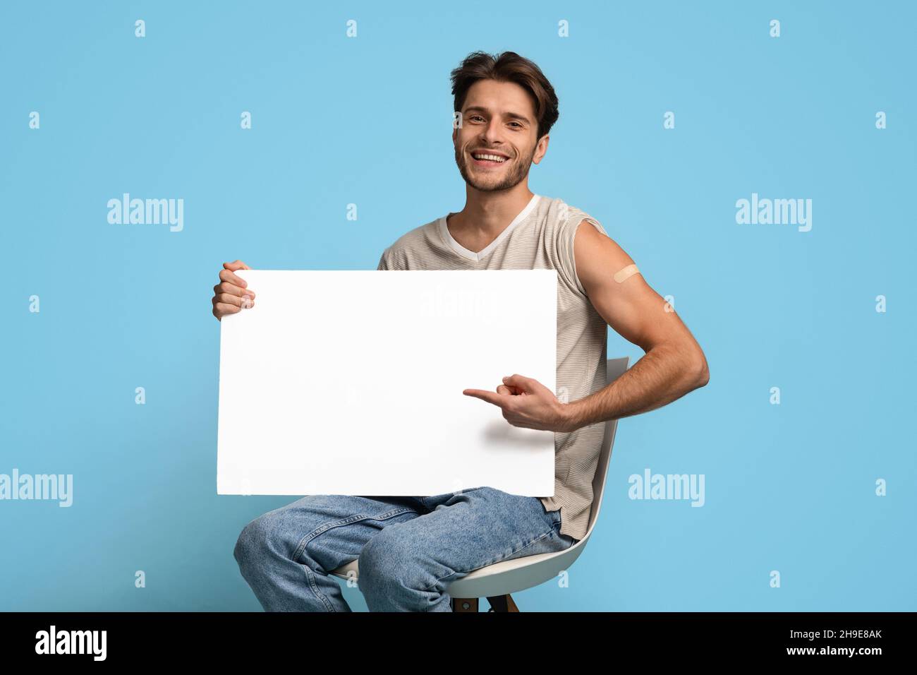 Impfwerbung Geimpfter Junger Mann, Der In Seinen Händen Auf Blank Placard Zeigt Stockfoto
