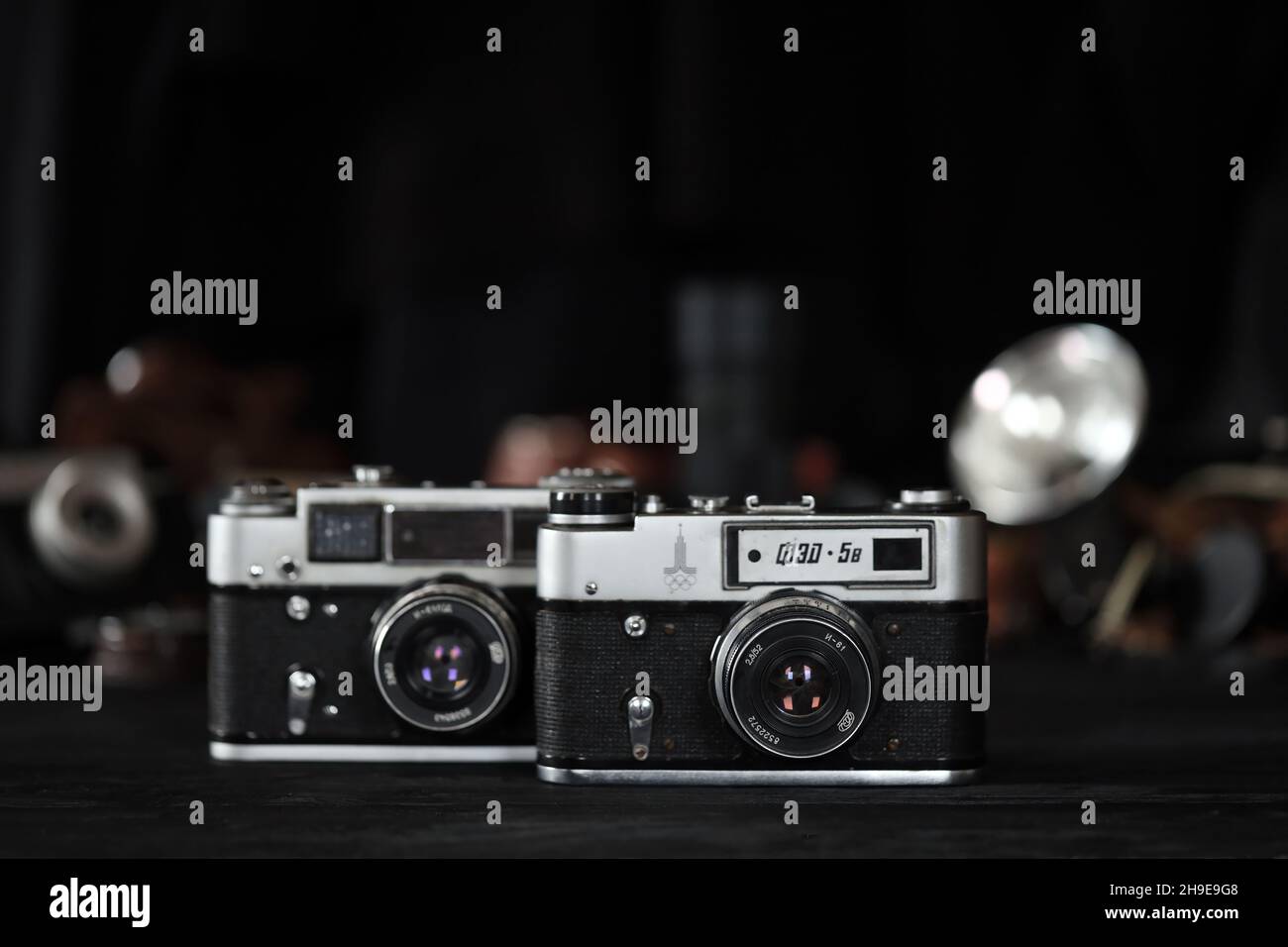 CHARKOW, UKRAINE - 27. APRIL 2021: Fed 4 und 5b Filmkamera und eine weitere alte Retro-Fotoausrüstung auf schwarzem Holztisch in der Dunkelkammer des Fotografen Stockfoto