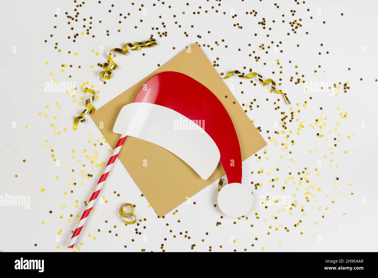 Weihnachtsmann Papierhut mit goldenem Konfetti und Sternen isoliert auf weißem Hintergrund. Stockfoto