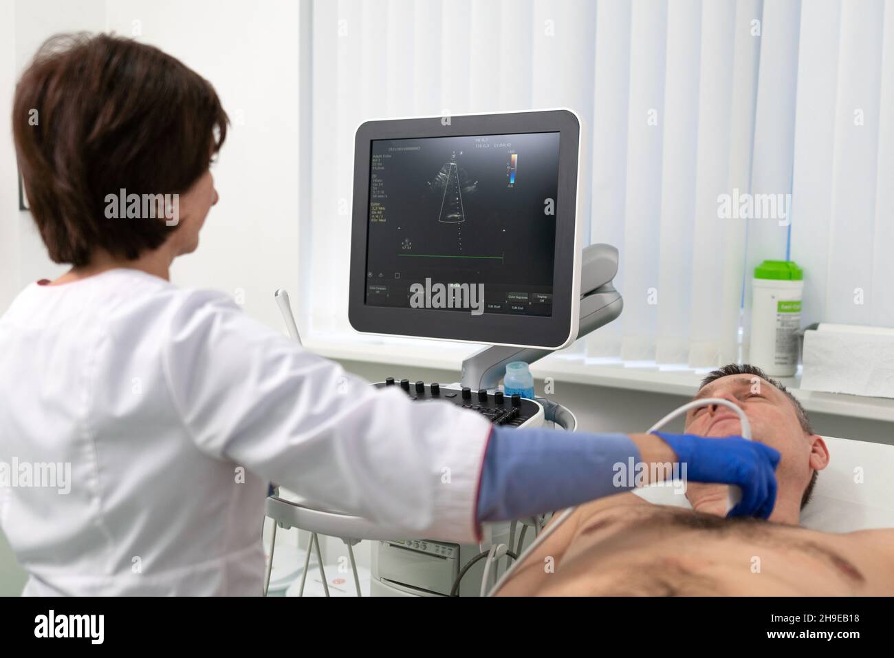 Ärztin macht Herzprüfung des Patienten Mann mit modernen Geräten in einer Kardiologie Klinik. Die Kardiologin schreit mit dem Herzen des Patienten Stockfoto