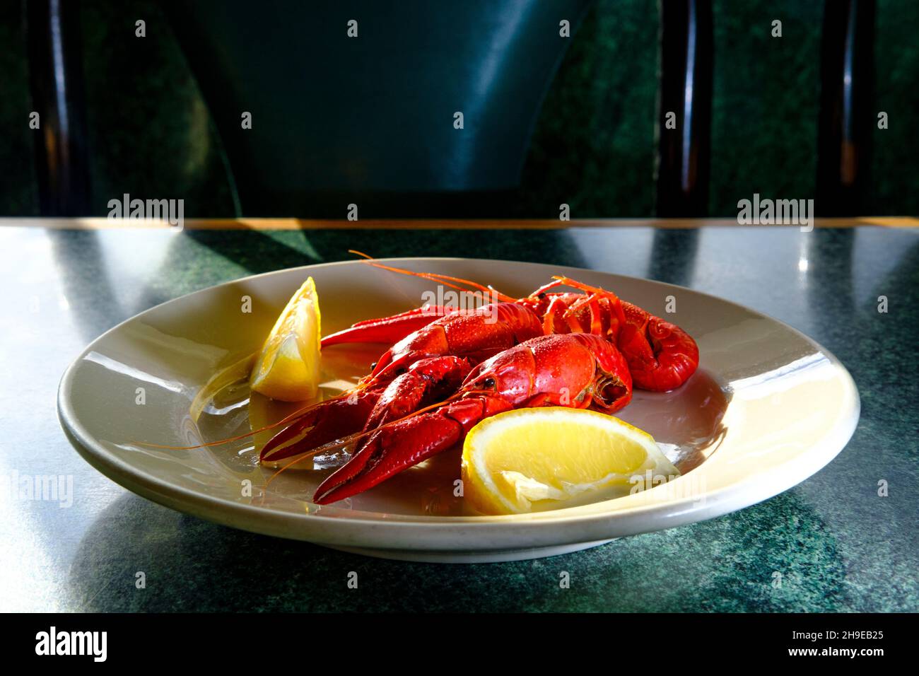 Abendessen mit gekochten buttrigen Krebsen und Meeresfrüchten, serviert mit Zitronenkeilen Stockfoto
