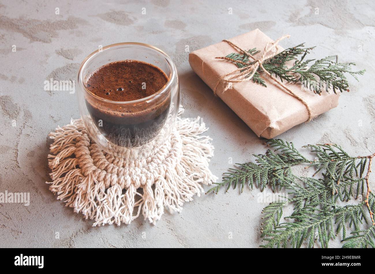 Americano Kaffee mit natürlichem Schaum. Heißer Kaffee aus doppelwandigen Glas auf grauem, betontem Hintergrund Stockfoto