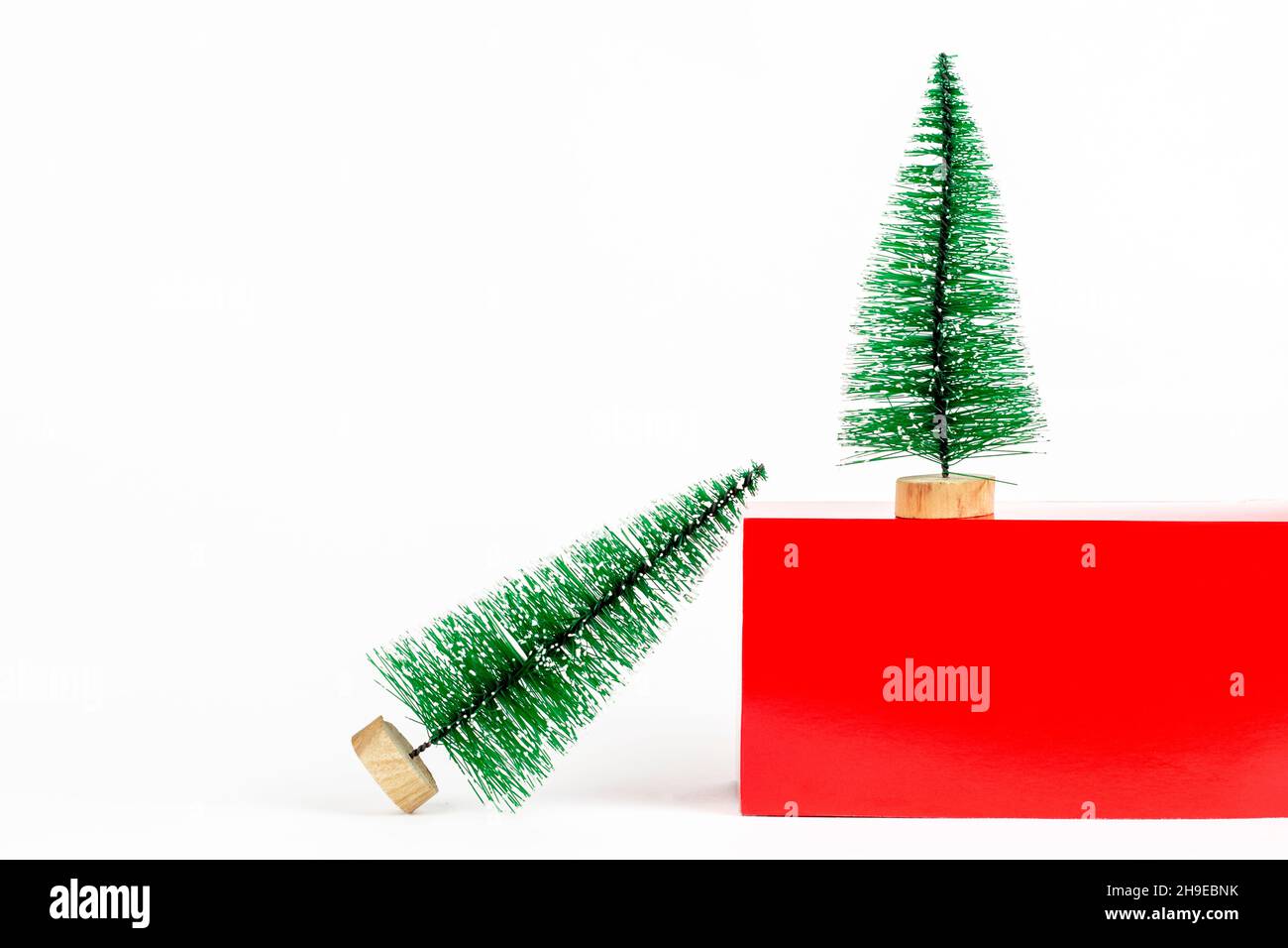 Weihnachtsbäume auf rotem Podium Würfel einfach minimal Urlaub Neujahr Hintergrund mit Kopierplatz. Stockfoto