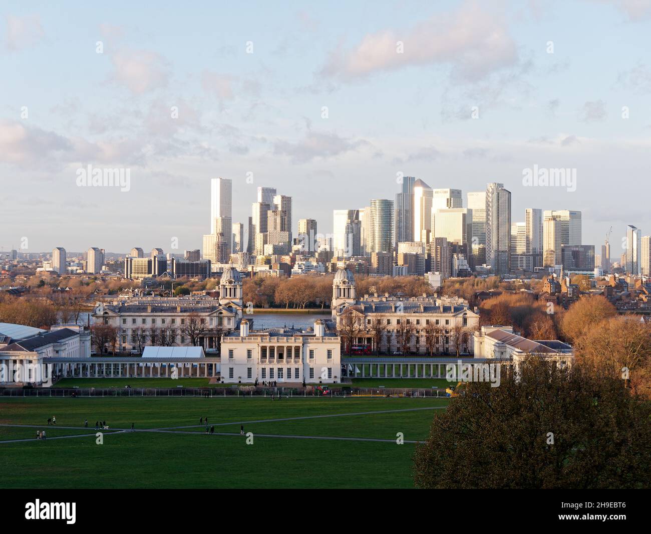 Blick vom Greenwich Park auf das Queens House und die Universität, mit den Wolkenkratzern von Canary Wharf dahinter. Stockfoto