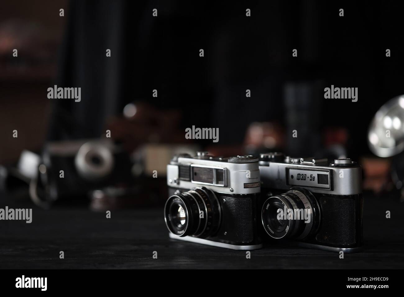 CHARKOW, UKRAINE - 27. APRIL 2021: Fed 4 und 5b Filmkamera und eine weitere alte Retro-Fotoausrüstung auf schwarzem Holztisch in der Dunkelkammer des Fotografen Stockfoto