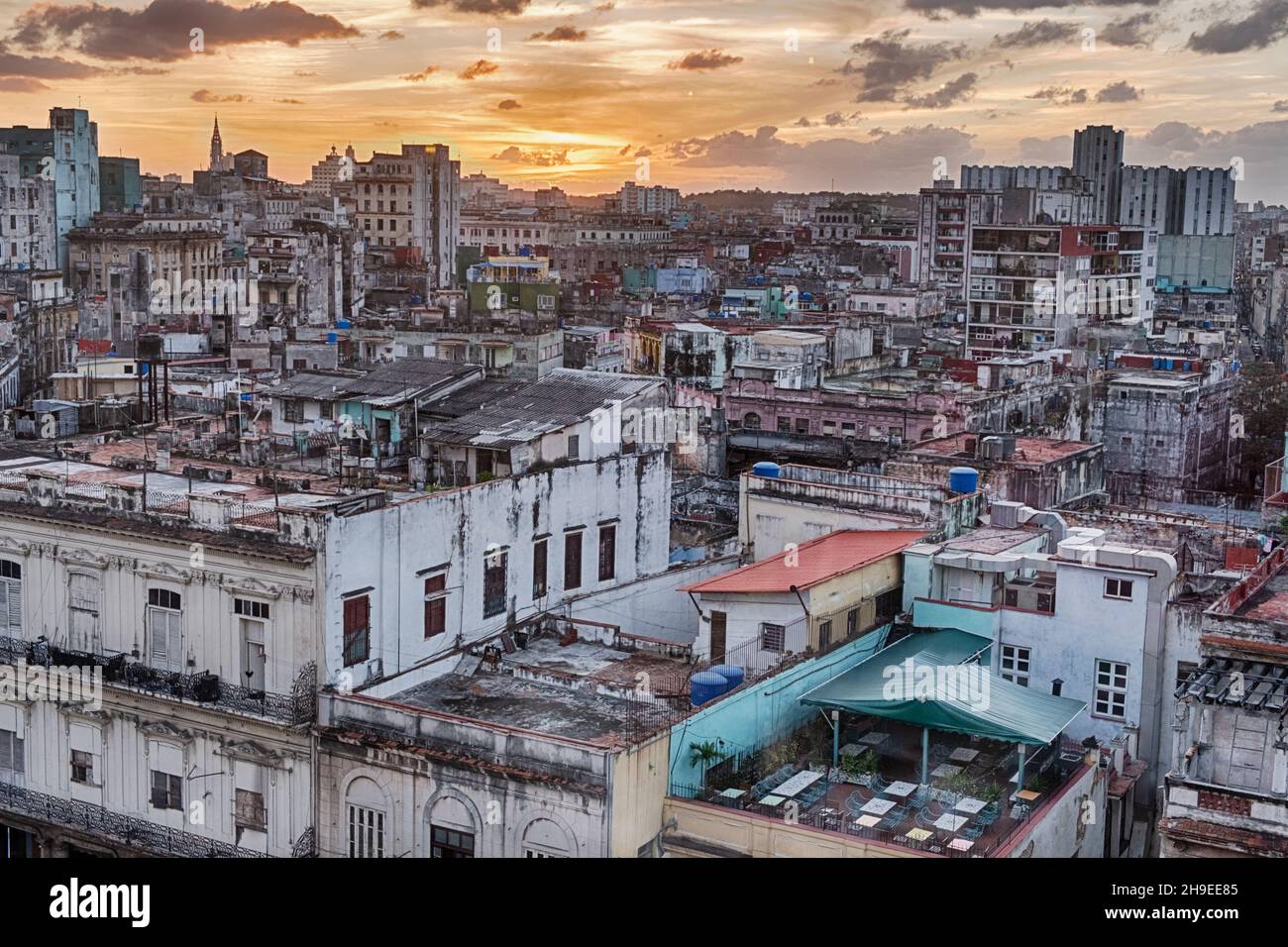 Ein Blick auf den Stadtteil Vedado in Havanna, Kuba wird von einem orangen Sonnenuntergang in der Ferne gefärbt. Stockfoto