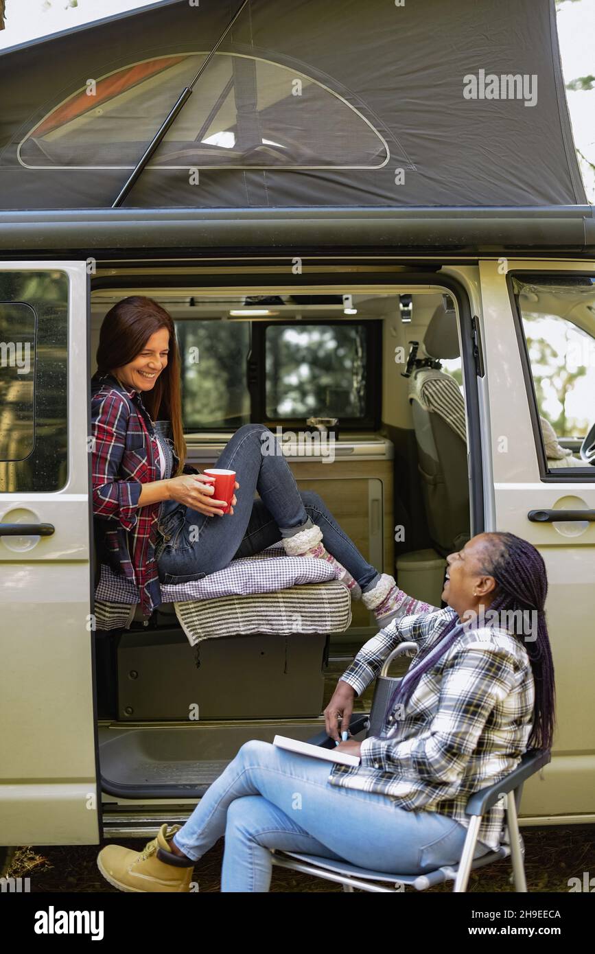 Diverse Reisende Frauen in der Nähe von Van auf dem Campingplatz Stockfoto