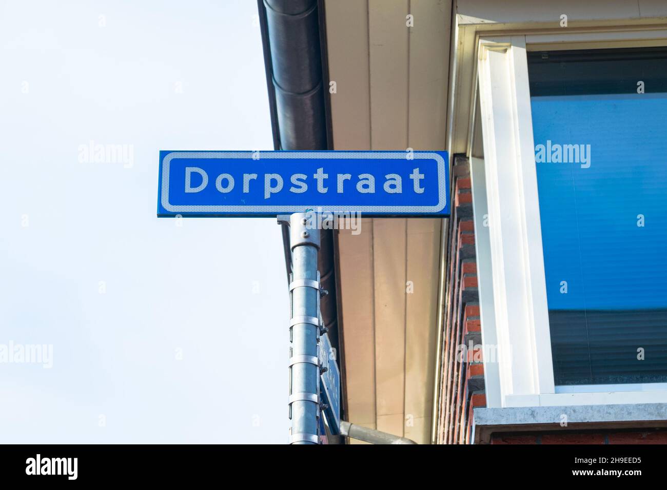 Straßenname Schild 'Dorpstraat' (dorpstraat bedeutet Dorfstraße auf Niederländisch). Ein Straßenname, der in fast jedem niederländischen Dorf zu finden ist. Stockfoto