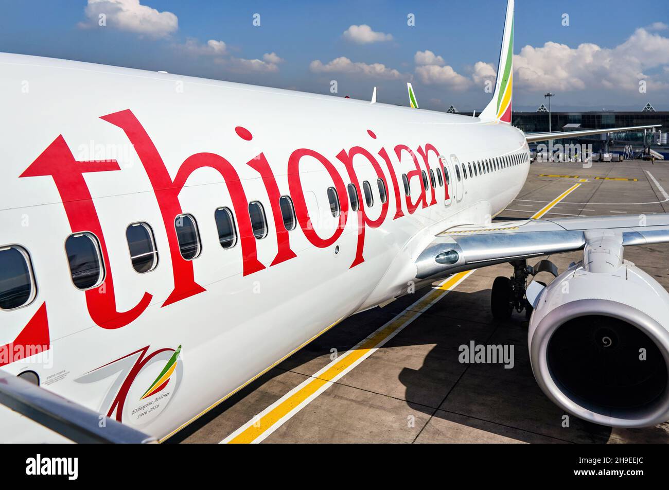Addis Abeba, Äthiopien - 23. April 2019: Die äthiopische Fluggesellschaft Boeing 737 wartet am sonnigen Tag auf dem Boden, das Flughafengebäude von Bole International in Backgrou Stockfoto