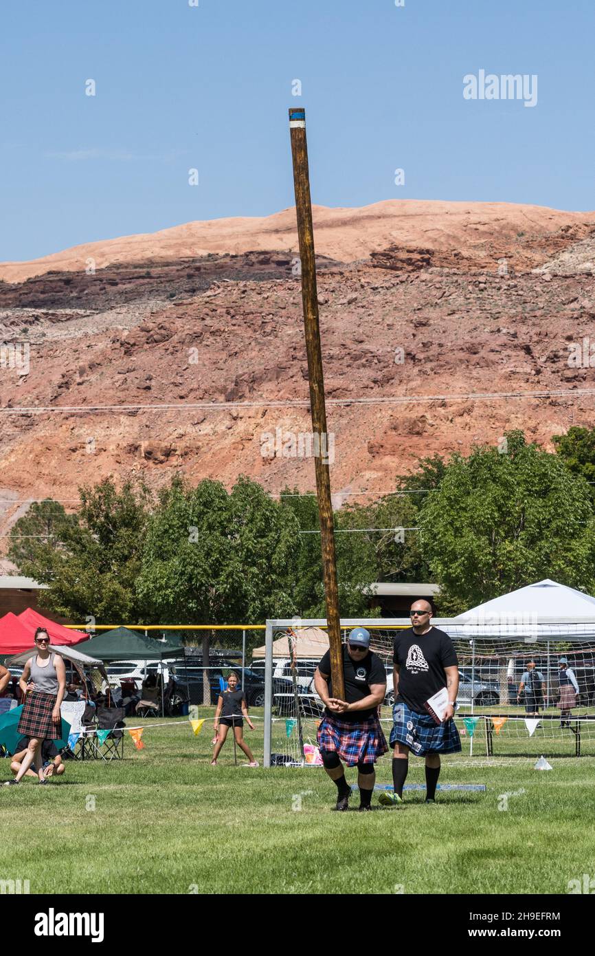 Ein Konkurrent macht seinen Lauf, um das Kabar bei einem Wettbewerb auf einem schottischen Festival in Utah zu werfen. Stockfoto