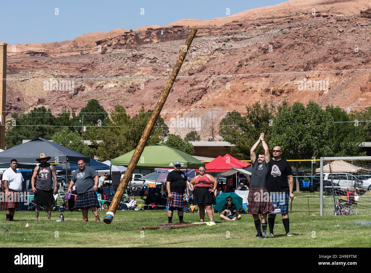 Ein Konkurrent tosses the caber in einem Wettbewerb auf einem schottischen Festival in Utah. Stockfoto