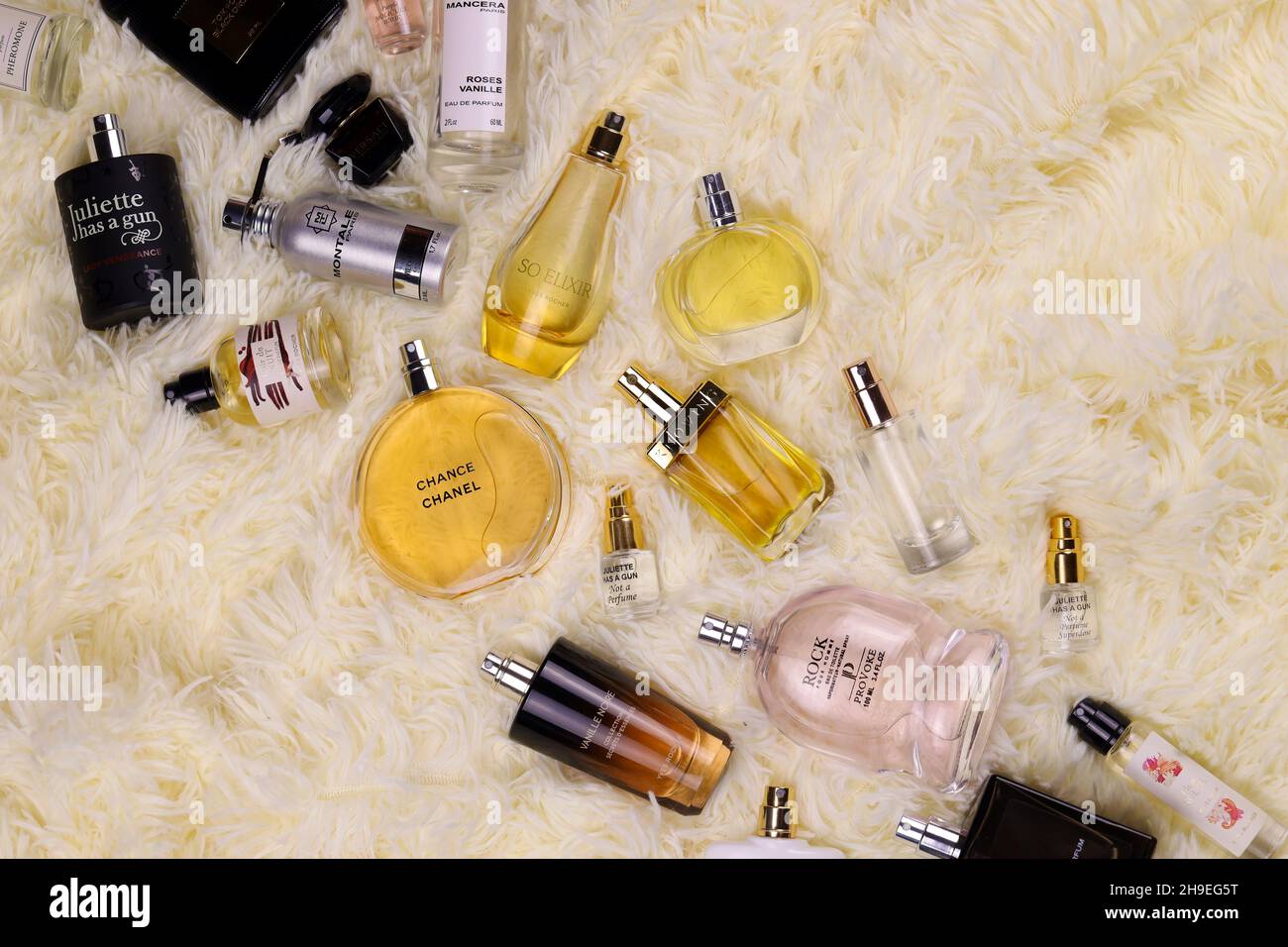 KHARKOV, UKRAINE - 12. JANUAR 2021: Viele Parfümflaschen mit berühmten Markennamen liegen auf flauschigen beigen Plaid. Luxuriöses Parfüm-Set der Extraklasse Stockfoto