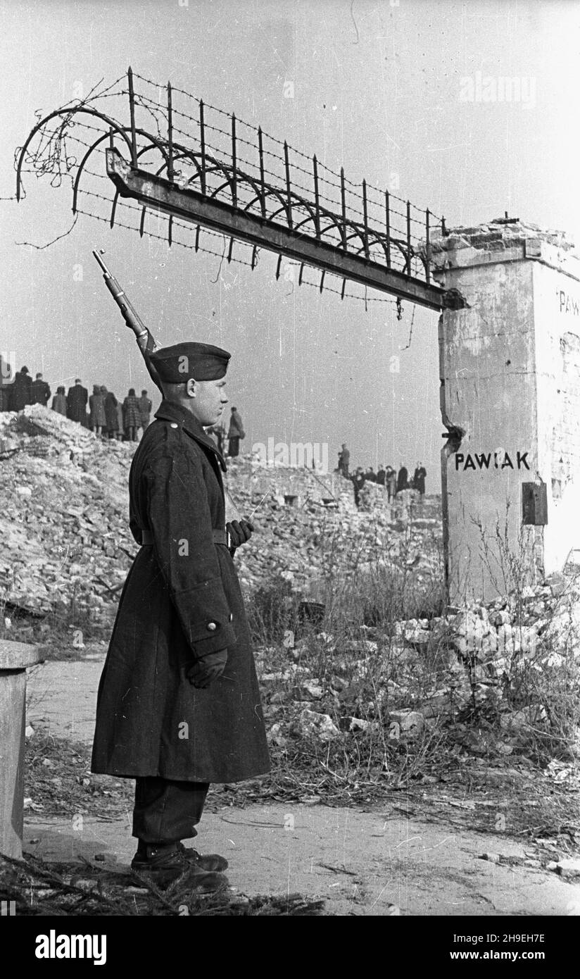 Warszawa, 1947-11-01. Msza ¿a³obna na gruzach Pawiaka w ho³dzie zamordowanym w niemieckich wiêzieniach i obozach. Nz. ¿o³nierz Wojska Polskiego trzyma wartê honorow¹ przed wejœciem na teren by³ego wiêzienia. W g³êbi uczestnicy mszy. ps/gr PAP Warschau, 1. November 1947. Die Trauermesse zu Ehren der in deutschen Gefängnissen und Konzentrationslagern ermordeten Menschen wurde in den Ruinen von Pawiak, dem ehemaligen Gefängnis, angeboten. Im Bild: Ein Soldat der polnischen Armee hält die Ehrenwache am Eingang des ehemaligen Gefängnisses. Im Hintergrund: Teilnehmer der Messe. ps/gr PAP Stockfoto