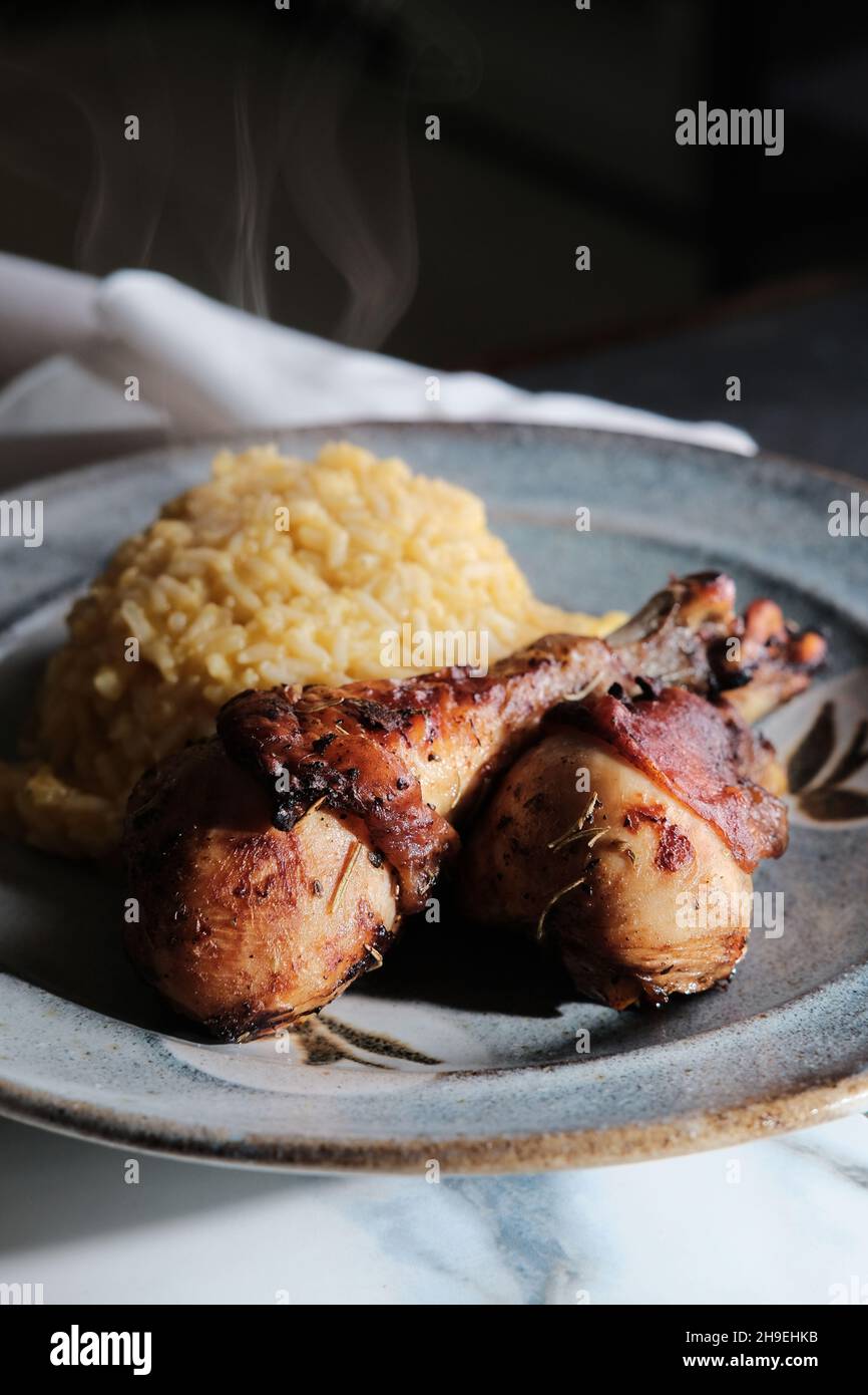 Peruanisches Abendessen pollo a la brasa Hähnchenschenkel mit Aji Amarillo Reis Risotto Stockfoto