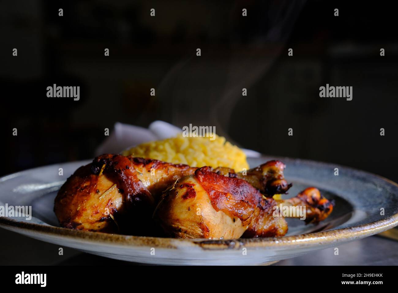 Peruanisches Abendessen pollo a la brasa Hähnchenschenkel mit Aji Amarillo Reis Risotto Stockfoto