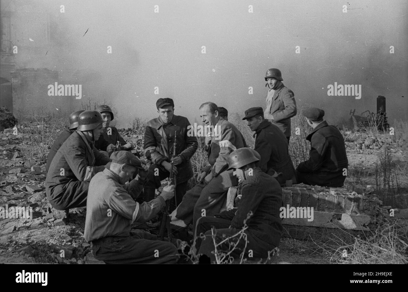 Warszawa, 1947-11. Starówka. Inscenizacja walk szturmowego batalionu im. Czwartaków Armii Ludowej. Oddzia³y AL bra³y udzia³ w Powstaniu Warszawskim do 23 sierpnia 1944 roku, m.in. na Woli, Starówce (ok. 400 ¿o³nierzy). NZ. wœród ¿o³nierzy Zenon Kliszko (w garniturze), szef klubu poselskiego Polskiej Partii Robotniczej i weteran Czwartaków. bk/mgs PAP Dok³adny dzieñ wydarzenia nieustalony. Warschau, 1947. November. Die Altstadt. Die Inszenierung der Kämpfe der Volksarmee Czwartakow Angriff Bataillon. Einheiten der Volksarmee kämpften bis zum 23. August 1944 im Warschauer Aufstand in Wola, Altstadt Stockfoto