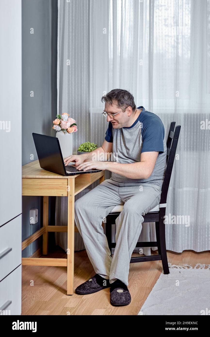 Presbyopie ist eine altersbedingte Sehbehinderung, ein 52-jähriger Mann, der versucht, Text auf dem Laptop-Bildschirm zu lesen. Stockfoto