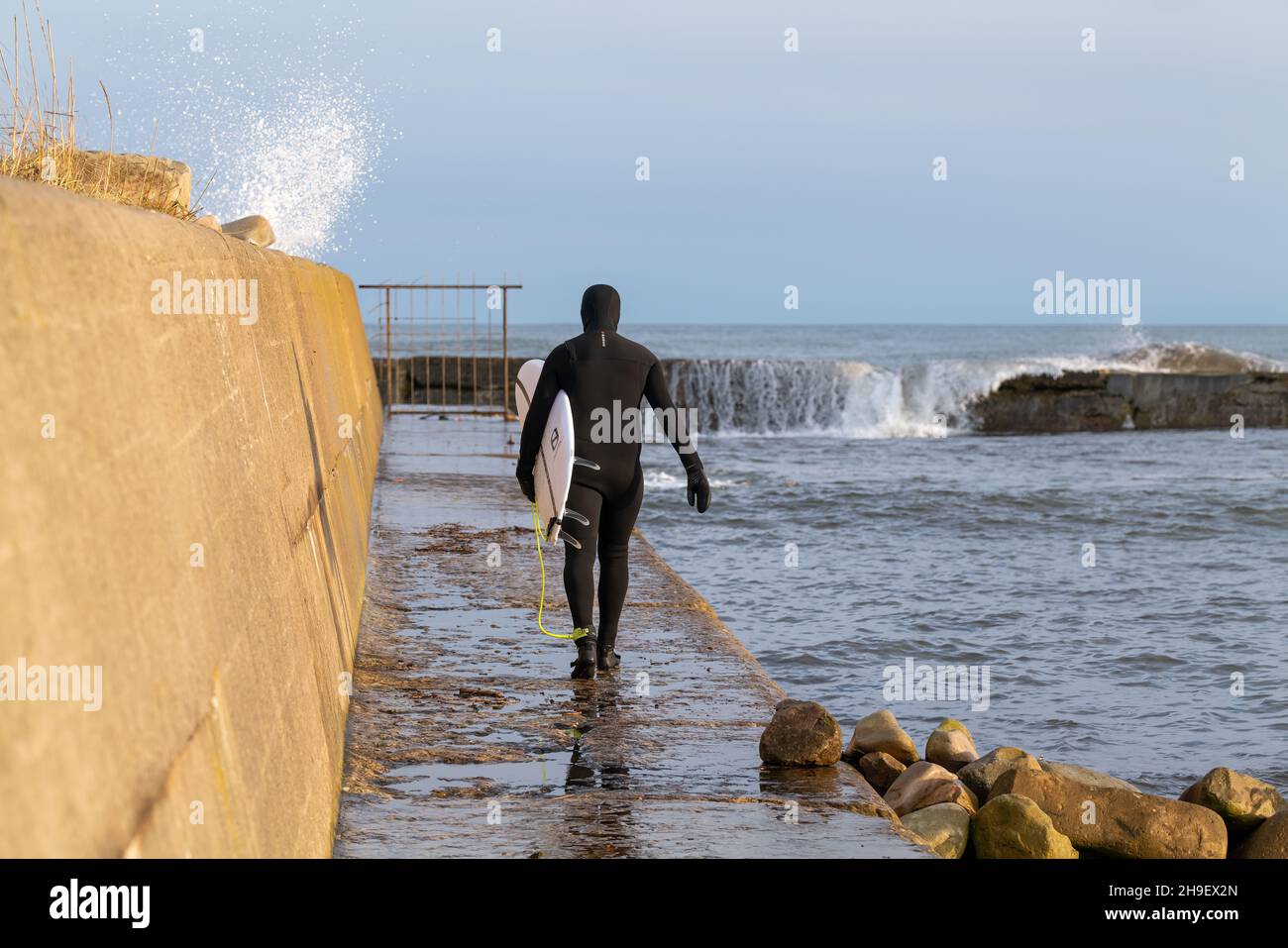 LOSSIEMOUTH, MORAY, SCHOTTLAND - 6. DEZEMBER 2021: Dies ist ein Mann, der am 6. Dece in Lossiemouth, Moray, Schottland, zu den East Beach Waves zum Surfen aufbrechen wird Stockfoto