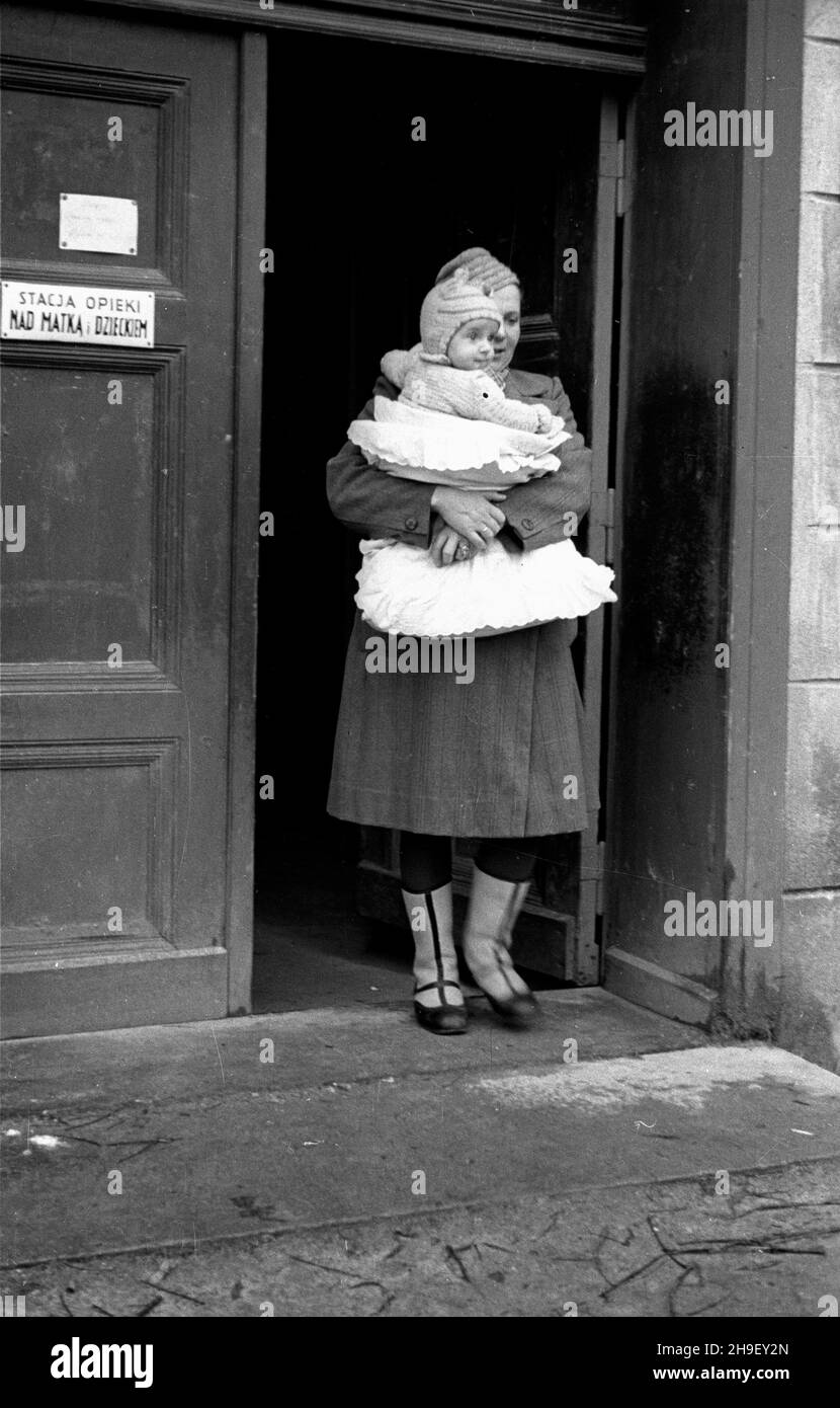 Sianów, 1947-12. Fabryka Zapa³ek. Historia zak³adu siêga po³owy XIX mit W 1946 r. kontrolê nad poniemieck¹ fabryk¹ przej¹³ Pañstwowy Monopol Zapa³czany. We wrzeœniu 1947 r. zakoñczono odbudowê ze zniszczeñ wojennych i uruchomiono produkcjê. NZ. matka z dzieckiem przed wejœciem do przyzak³adowej przychodni. po/mgs PAP Dok³adny dzieñ wydarzenia nieustalony. Sianow, Dezember 1947. Match Factory. Seine Geschichte reicht bis zur Mitte des 19th. Jahrhunderts zurück. 1946 wurde die ehemals deutsche Fabrik von State Match Monopoly übernommen. Im Jahr 1947 wurde es nach den Verwüstungen des Krieges und der Produktion wieder aufgebaut. Pi Stockfoto