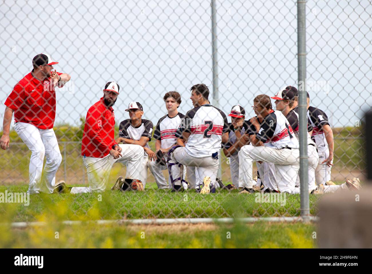 Trainer, die während der Sommersaison mit einem Baseballteam im Teenageralter sprechen. St. Paul Minnesota, USA Stockfoto