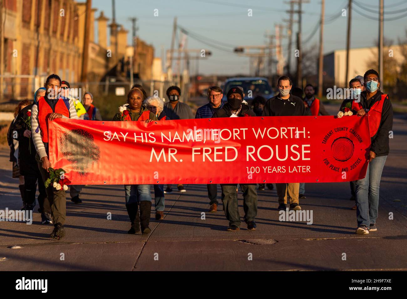 Fort Worth, Texas, USA. 6th Dez 2021. Vor hundert Jahren wurde ein schwarzer Mann namens Fred Rouse von einem wütenden Mob weißer Männer aus Fort Worth, Texas, ermordet. Heute 12/06/2021, in Fort Worth, Texas, in der Nähe eines beliebten Touristengebiets namens The Stockyards, wo früher Rinder zur Versteigerung verkauft wurden, aber jetzt ein Ort für einen Vorgeschmack auf das Cowboy-Leben ist. Eine Gruppe von fünfundzwanzig Personen versammelte sich, darunter Fred Rouse, der zweite, der Urenkel des verstorbenen Herrn Rouse. Die Gruppe hielt die erste Mahnwache mit 100 Rosen ab, eine Rose für jedes Jahr, in dem sein Leben in der Geschichte vergessen wurde. (Bild: © Chris Rusan Stockfoto