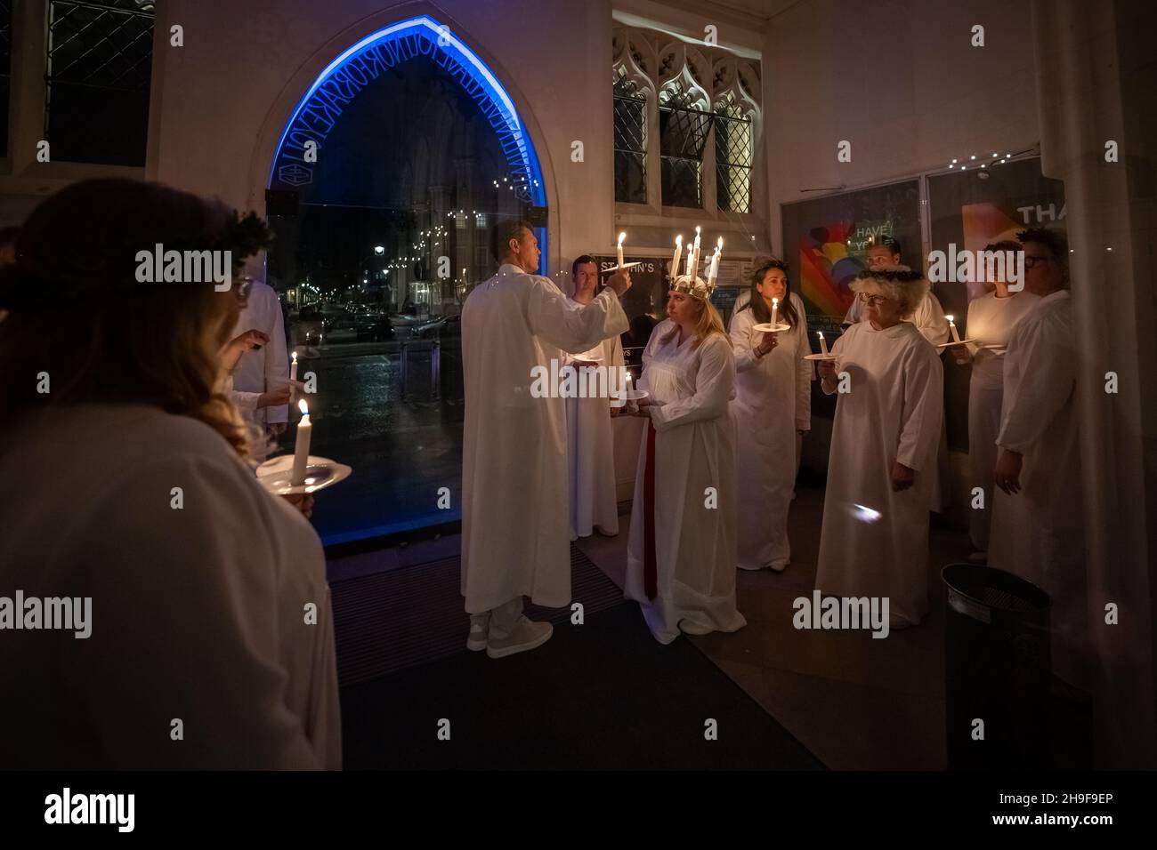 London, Großbritannien. 6th. Dezember 2021. Sarah Evander, die die Rolle der Lucia spielt, leitet die Prozession während des traditionellen skandinavischen Konzerts ‘Sankta Lucia’ des London Nordic Choir in der St. John’s Church unter der Leitung von Carina Einarson. Der Gottesdienst besteht aus einer Prozession von Chören bei Kerzenschein, die von einem Mädchen, Lucia, geführt wird, das eine Krone aus Kerzen und eine rote Schärpe um ihre Taille trägt. Kredit: Guy Corbishley/Alamy Live Nachrichten Stockfoto