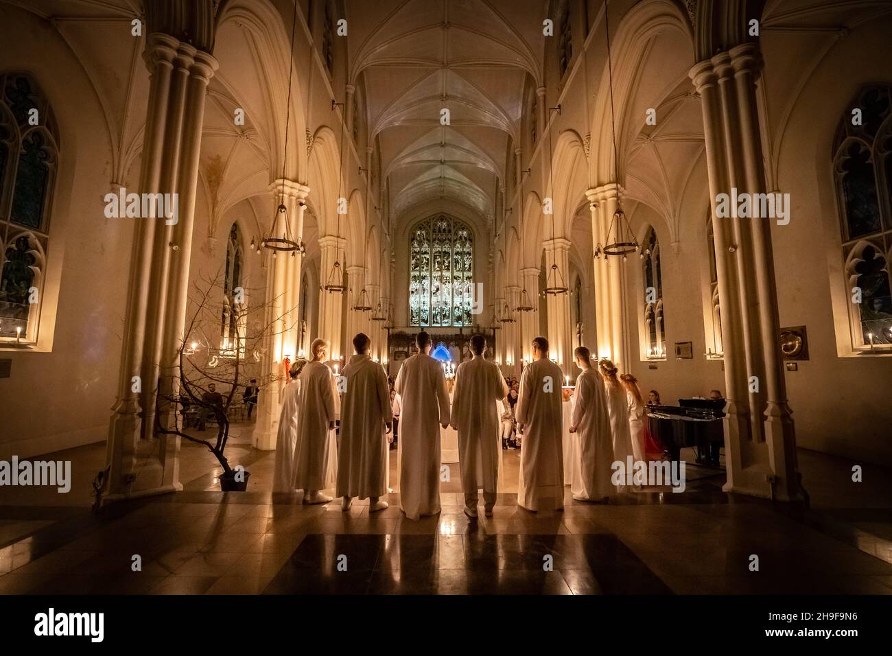 London, Großbritannien. 6th. Dezember 2021. Sarah Evander, die die Rolle der Lucia spielt, leitet die Prozession während des traditionellen skandinavischen Konzerts ‘Sankta Lucia’ des London Nordic Choir in der St. John’s Church unter der Leitung von Carina Einarson. Der Gottesdienst besteht aus einer Prozession von Chören bei Kerzenschein, die von einem Mädchen, Lucia, geführt wird, das eine Krone aus Kerzen und eine rote Schärpe um ihre Taille trägt. Kredit: Guy Corbishley/Alamy Live Nachrichten Stockfoto