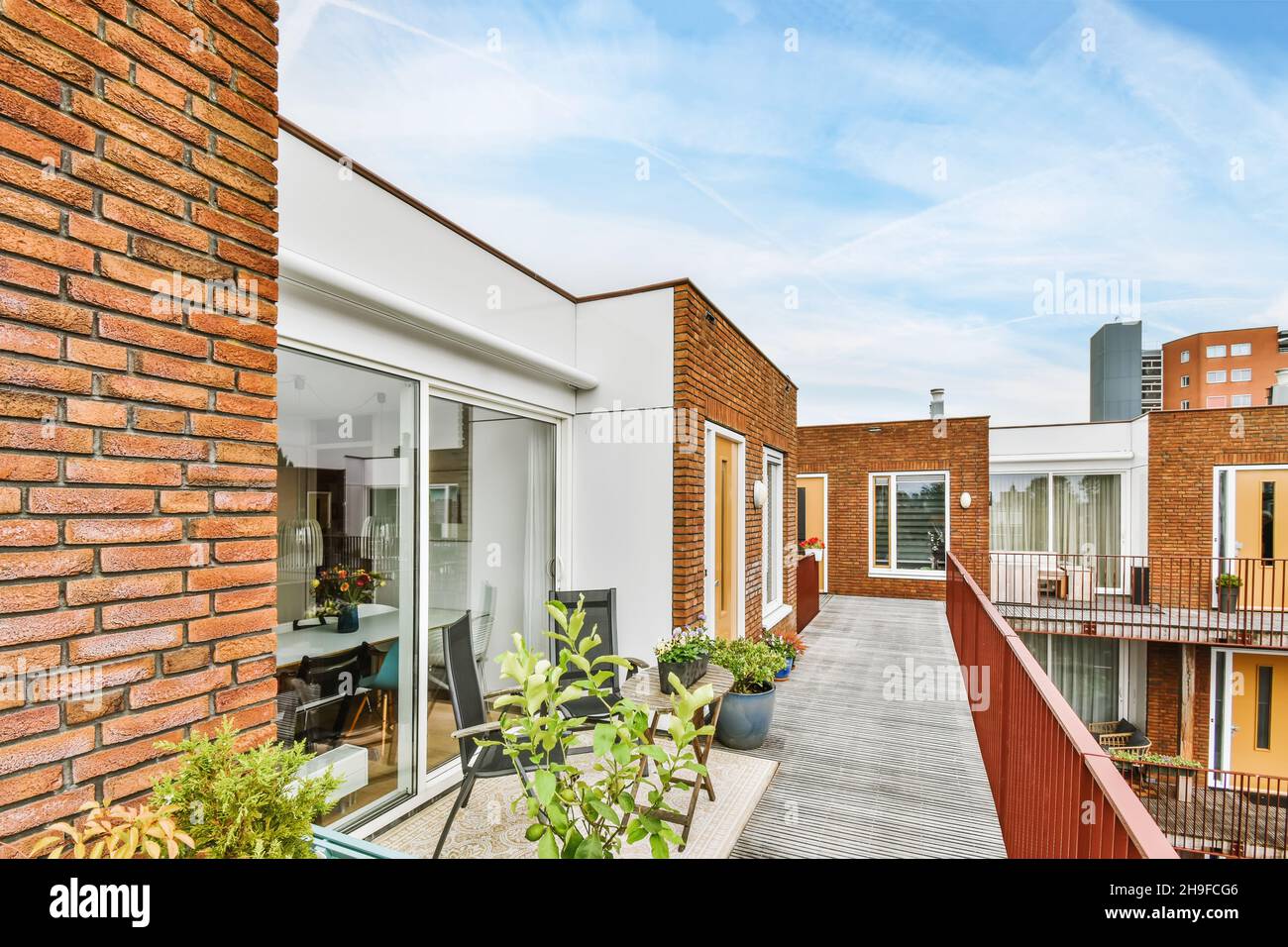 Stilvoller Balkon mit Blumen, die alle Apartments miteinander verbinden Stockfoto