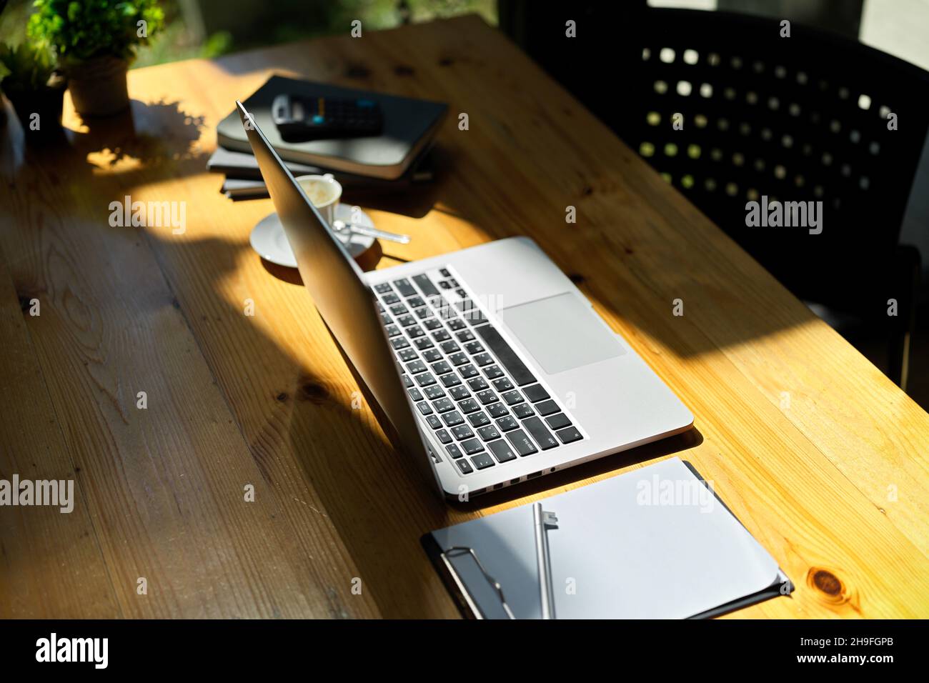 Laptop-Computer mit Bürobedarf auf Holzschreibtisch. Geschäftsausrüstungskonzept. Offener Laptop-Mockup. Stockfoto