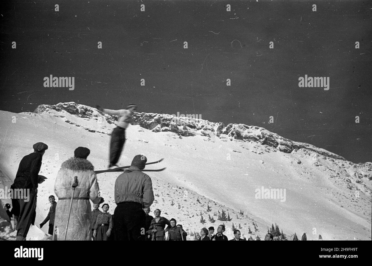 Zakopane, 1948-02-02. Mistrzostwa Polski Juniorów w konkurencjach narciarskich. W najwiêkszej po wojnie imprezie sportowej uczestniczy³o Ponad 650 zawodników. NZ. Zawody na skoczni terenowej. W eim masyw Giewontu. po/gr PAP Zakopane, 2. Februar 1948. Polen Junioren-Meisterschaften bei Ski-Events. Die größte Sportveranstaltung nach dem Krieg zog über 650 Teilnehmer an. Im Bild: Eine Veranstaltung auf einer Schanze. Im Hintergrund der Berg Giewont. po/gr PAP Stockfoto