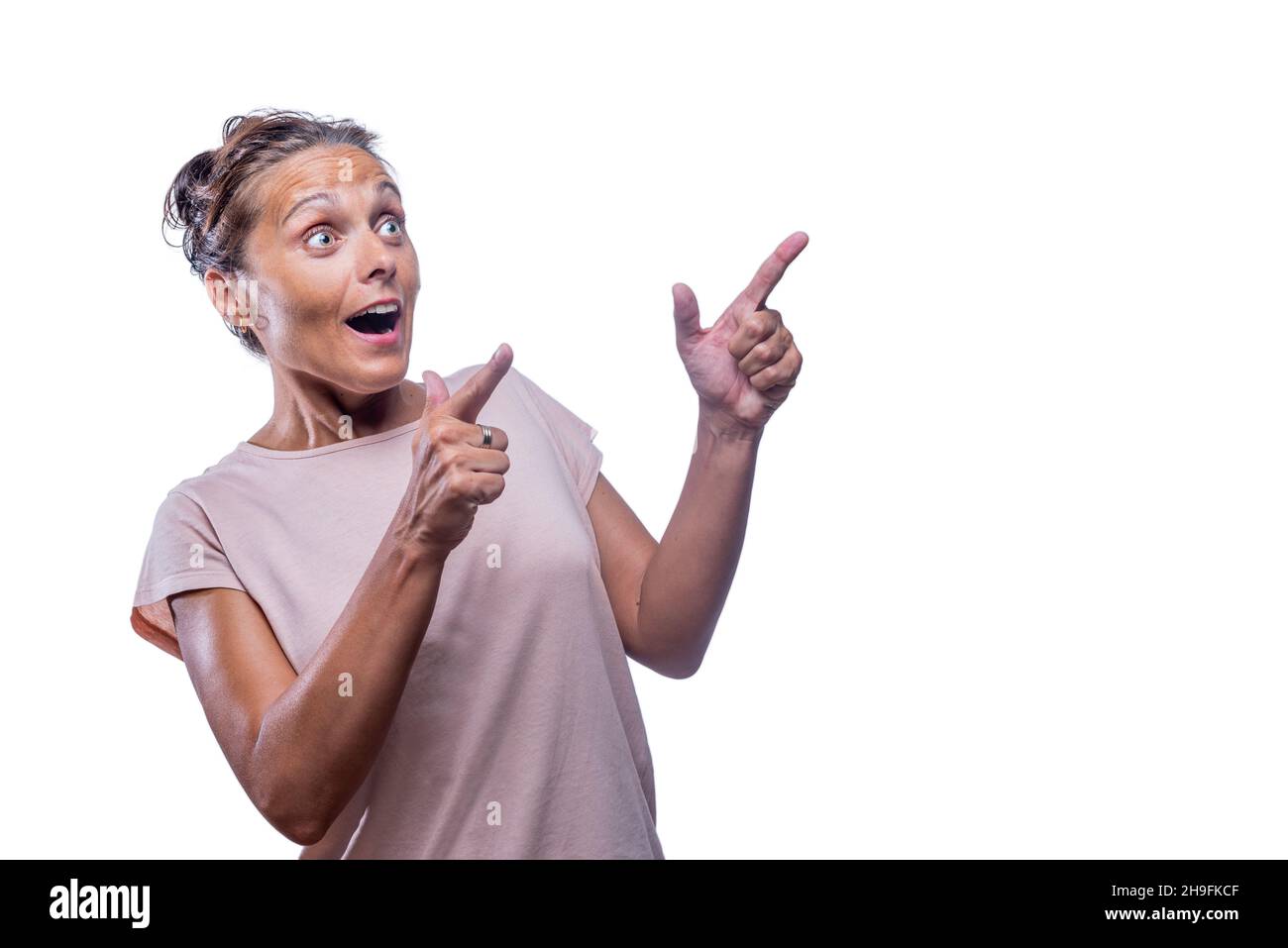 Überraschte Frau, die mit dem Zeigefinger beider Hände zeigte Stockfoto