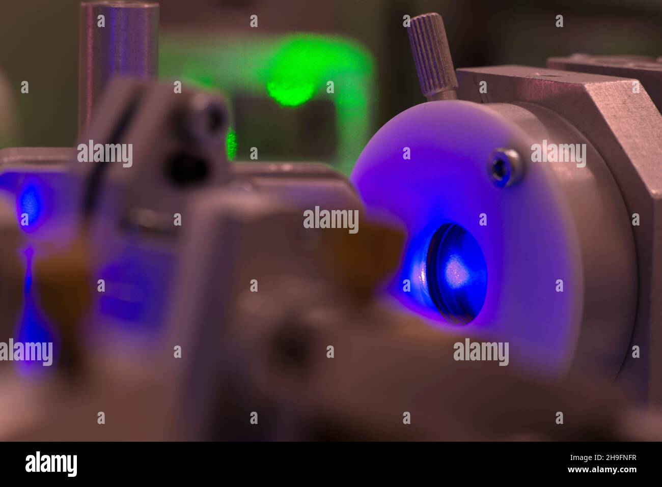 Ultraviolette Laserstrahlung im Inneren eines komplizierten wissenschaftlichen Systems, Fokus auf Strahlfleck Stockfoto