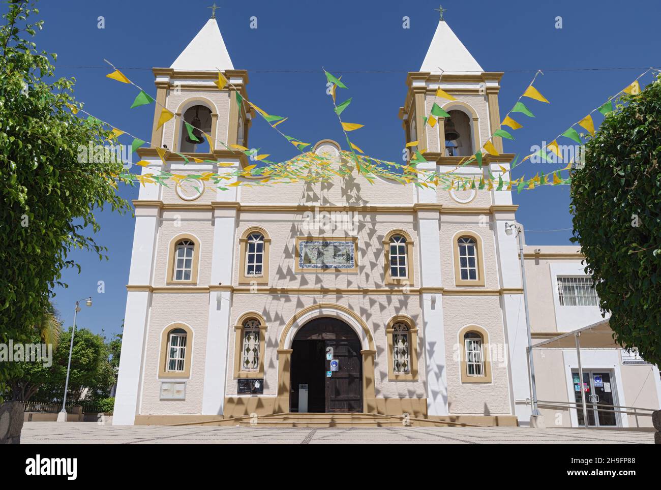 Mission San Jose del Cabo, in Baja California Sur, Mexiko. Das Gebäude ist mit grünen und gelben Dreiecksfahnen dekoriert. Stockfoto