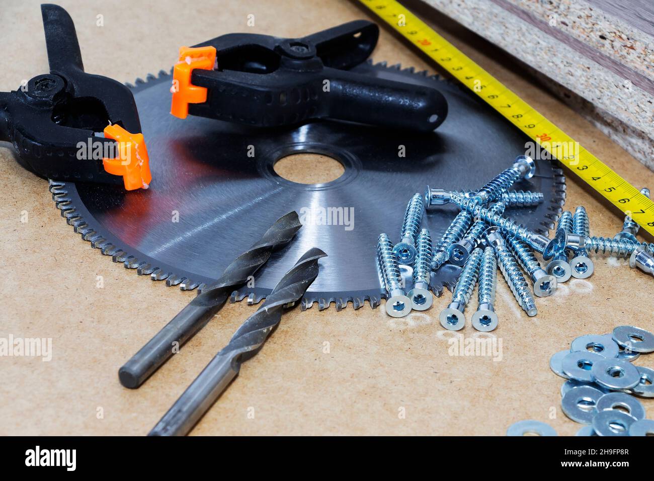 Schrauben, Bestätigungen für Möbel, Maßband, liegen auf dem Tisch. Möbelproduktion. Stockfoto