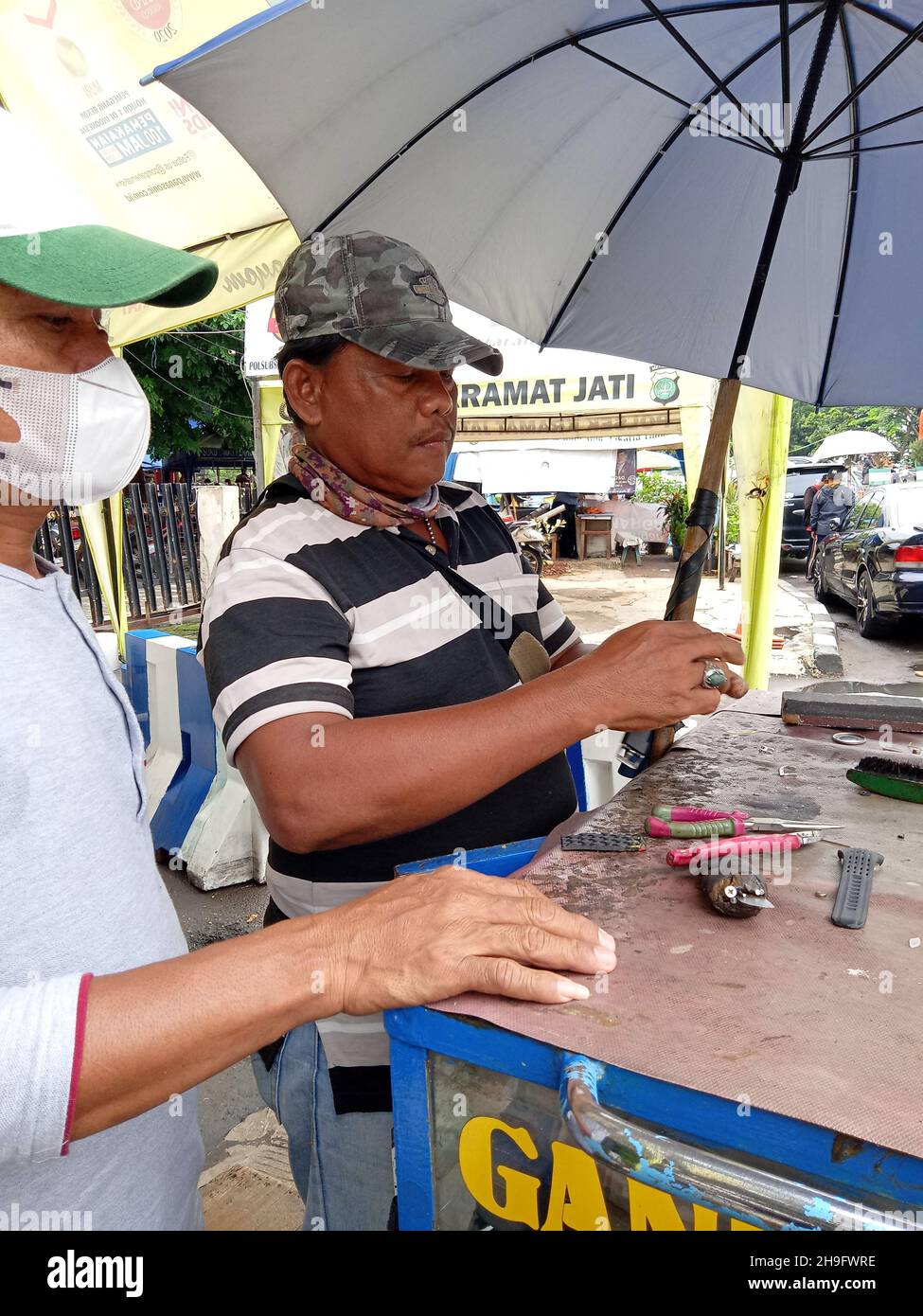 Editorial Photo, Indonesien, East Jakarta, Kramat Jati, 12. Dezember 2021, Mann repariert oder ersetzt Kundenarmbanduhr Stockfoto