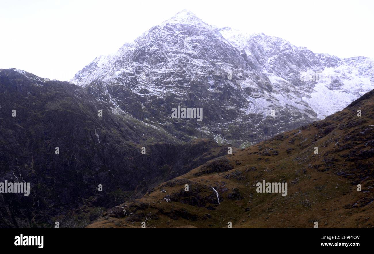 Winter im Snowdonia National Park (Eryri), Wales, Großbritannien. Schnee auf dem Gipfel des Snowdon (Yr Wyddfa), dem höchsten Berg in Wales, von der Bergarbeiterspur aus gesehen, als sich der Sturm Barra nähert. Es wird erwartet, dass starke Winde und Schnee das vereinigte königreich treffen werden. Der Berg liegt 1.085 Meter (3.560 Fuß) über dem Meeresspiegel und ist der höchste Punkt der Britischen Inseln außerhalb der schottischen Highlands. Stockfoto