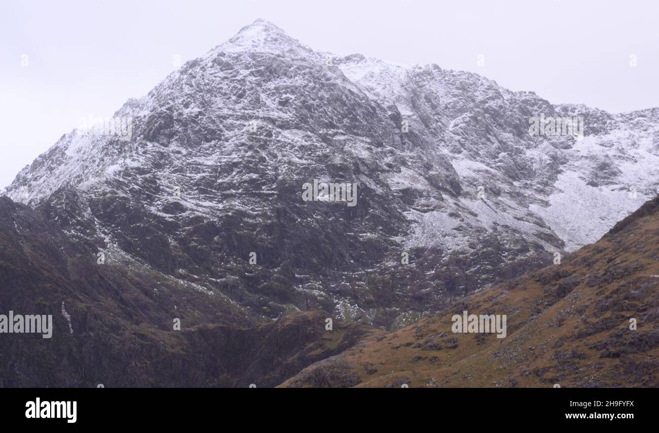 Winter im Snowdonia National Park (Eryri), Wales, Großbritannien. Schnee auf dem Gipfel des Snowdon (Yr Wyddfa), dem höchsten Berg in Wales, von der Bergarbeiterspur aus gesehen, als sich der Sturm Barra nähert. Es wird erwartet, dass starke Winde und Schnee das vereinigte königreich treffen werden. Der Berg liegt 1.085 Meter (3.560 Fuß) über dem Meeresspiegel und ist der höchste Punkt der Britischen Inseln außerhalb der schottischen Highlands. Stockfoto