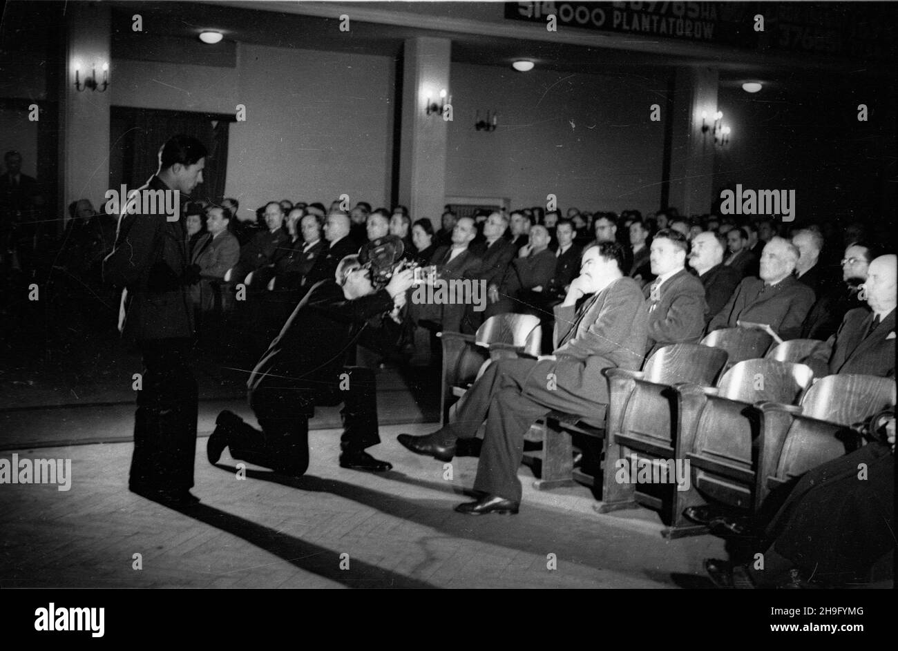 Warszawa, 1948-03-23. Ogólnopolski Zjazd Cukrowniczy na zakoñczenie kampanii cukrowniczej 1947-1948. Zwyciêskie zespo³y w wyœcigu pracy otrzyma³y przechodnie sztandary od Centralnego Zarz¹du Cukrowniczego. NZ. Podsekretarz stanu w ministerstwie rolnictwo Stanis³aw Tkaczow filmowany przez operatora Polskiej Kroniki Filmowej. wb PAP Warschau, 23. März 1948. Der Nationale Zuckersektorkongress am Ende der Zuckerrübenernte um die Wende von 1947 und 1948. Arbeitsgruppen, Gewinner des Arbeitsrennens wurden mit den Challenge-Transparenten des Central Sugar Sector Board geehrt. Abgebildet: Untersek Stockfoto