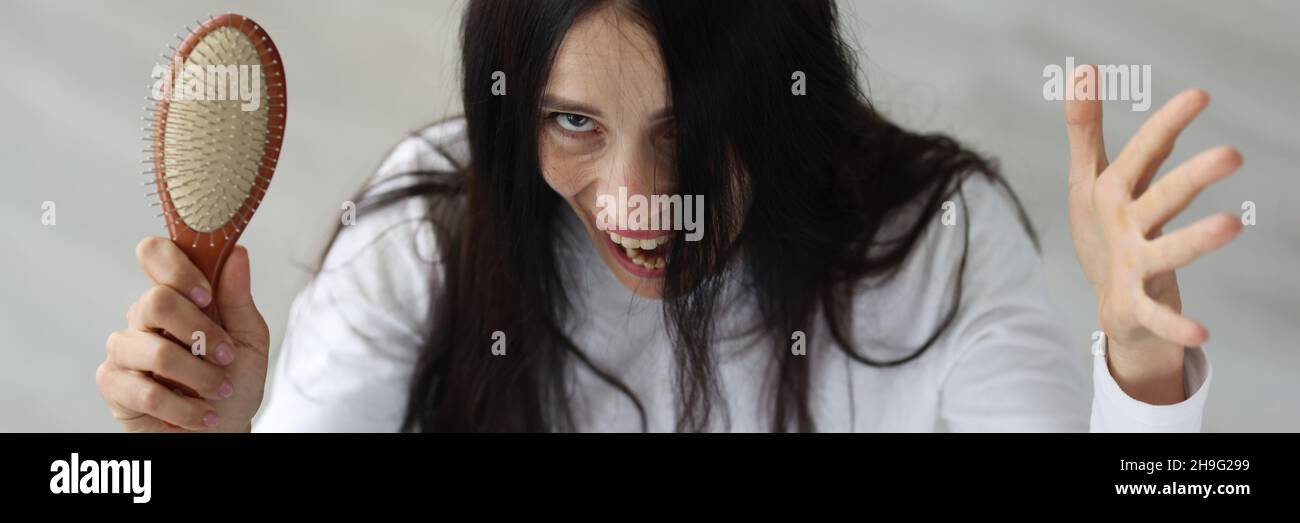 Verängstigte Frau hält Haarbürste und schreit aus der Nähe Stockfoto